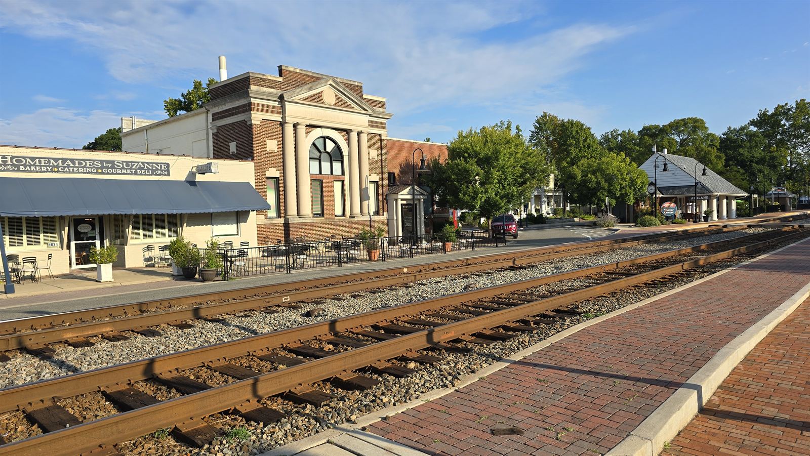 Railroad tracks running through downtown Ashland, Virginia, past local shops and a historic brick building